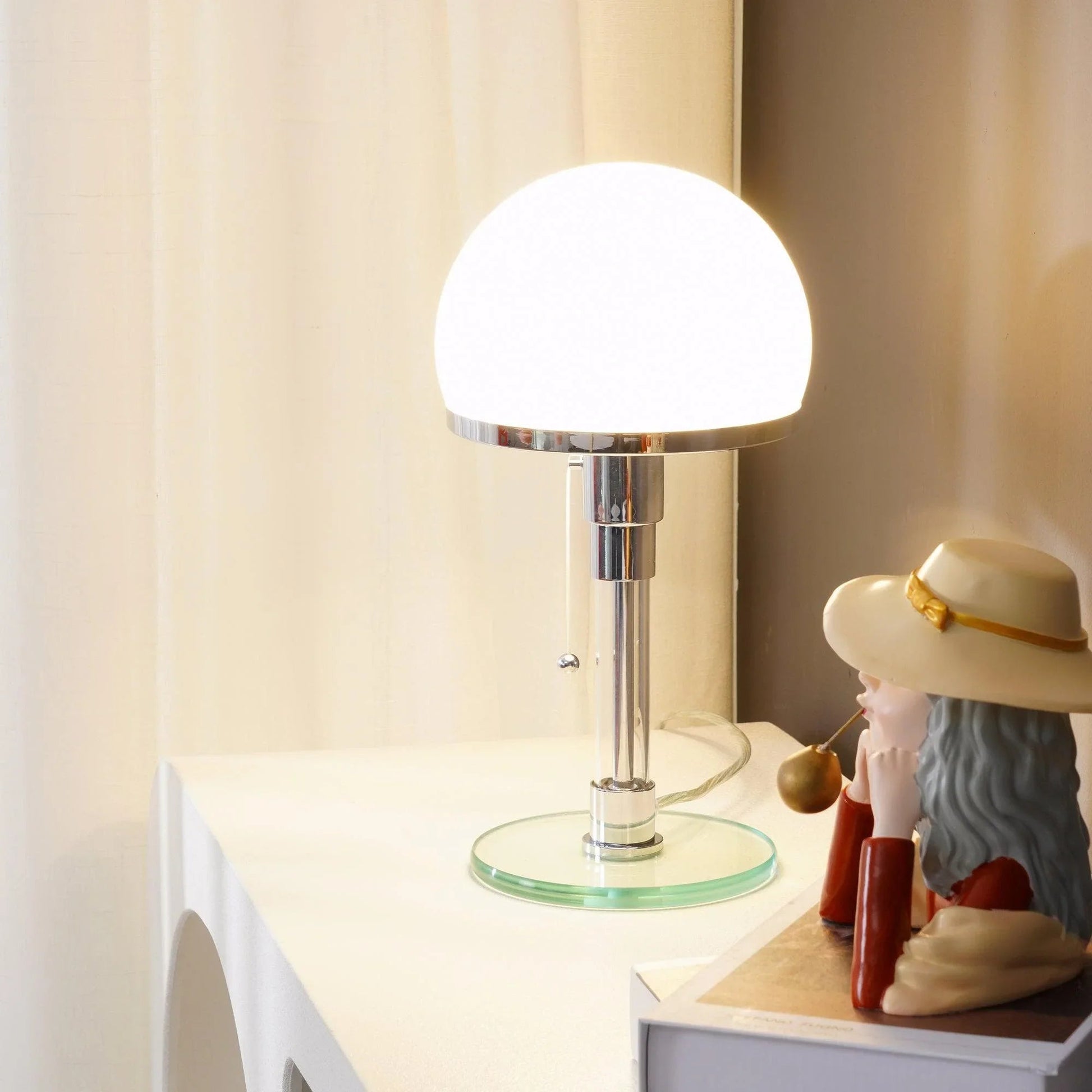 Lumotrot glass dome table lamp creating a warm, ambient glow on a desk