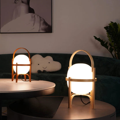 Living room corner illuminated by a warm wood and glass lantern table lamp