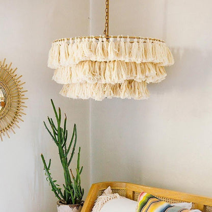 Round tiered silhouette of a fabric tassel chandelier suspended by a metal chain