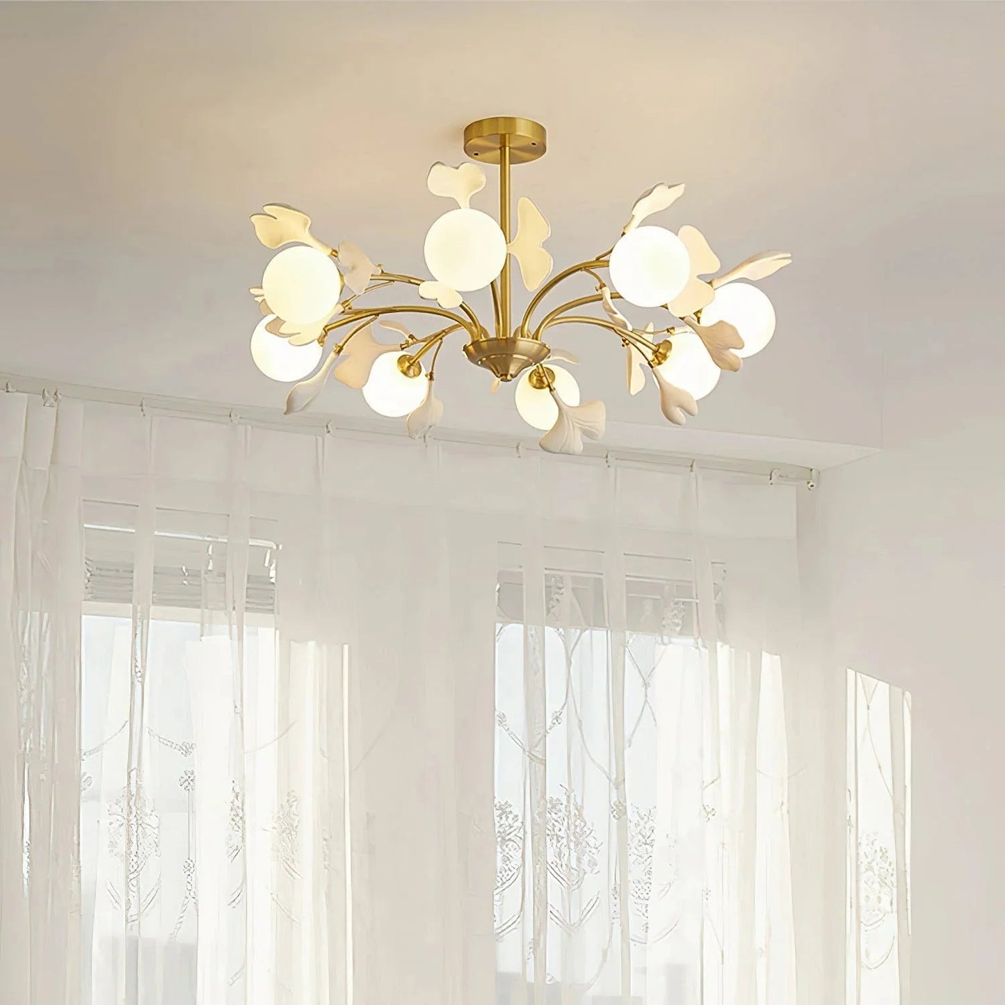 Ceiling-mounted brass chandelier featuring organic ceramic leaf design