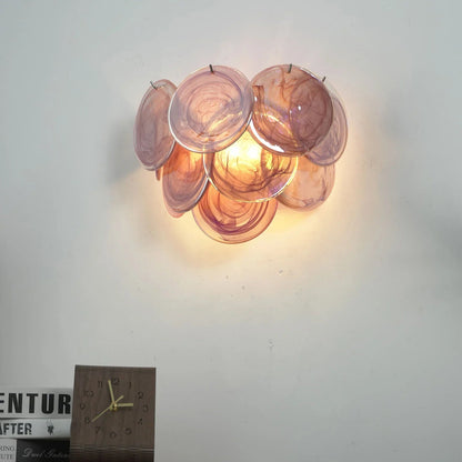 Close-up of iridescent rose blown glass discs on wall sconce