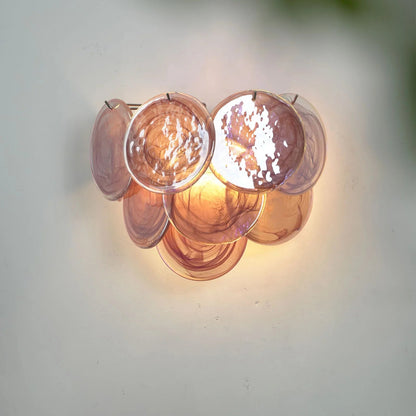 Elegant bedroom illuminated by a soft rose-tinted glass wall sconce