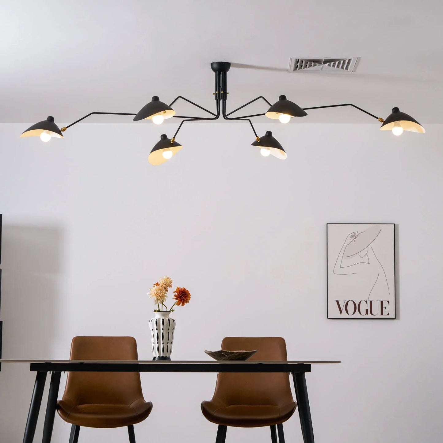 Installation view of a black metal ceiling light with adjustable arms